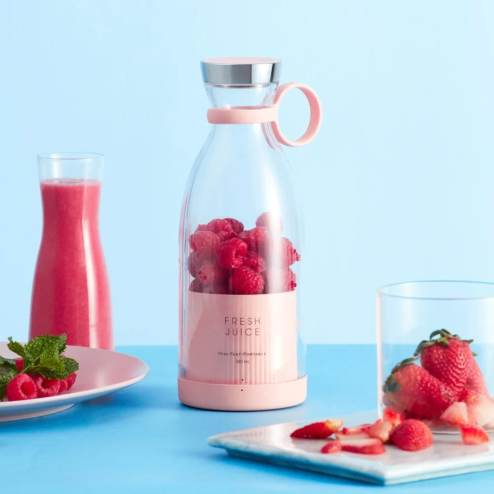 Pink portable Fresh Juice electric blender with stainless steel blade – front view on white background