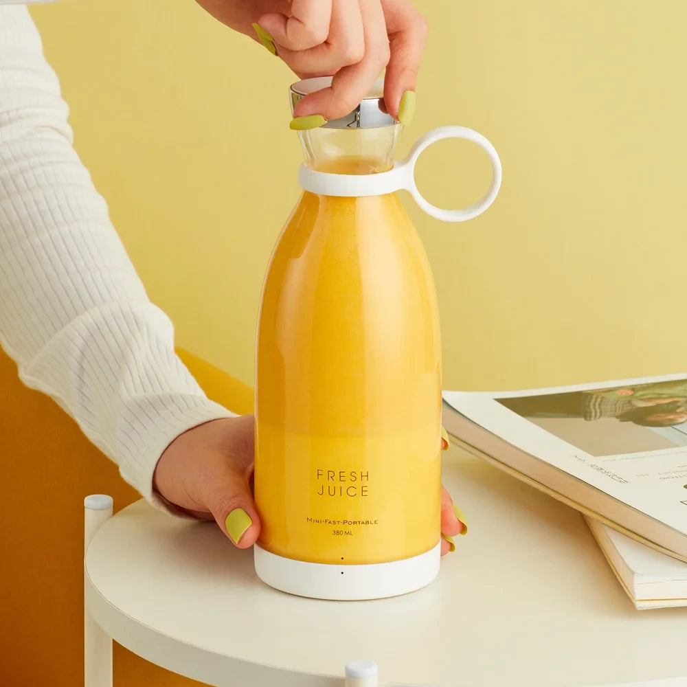 Yellow juice portable blender labeled 'Fresh Juice' held by a person against a yellow background