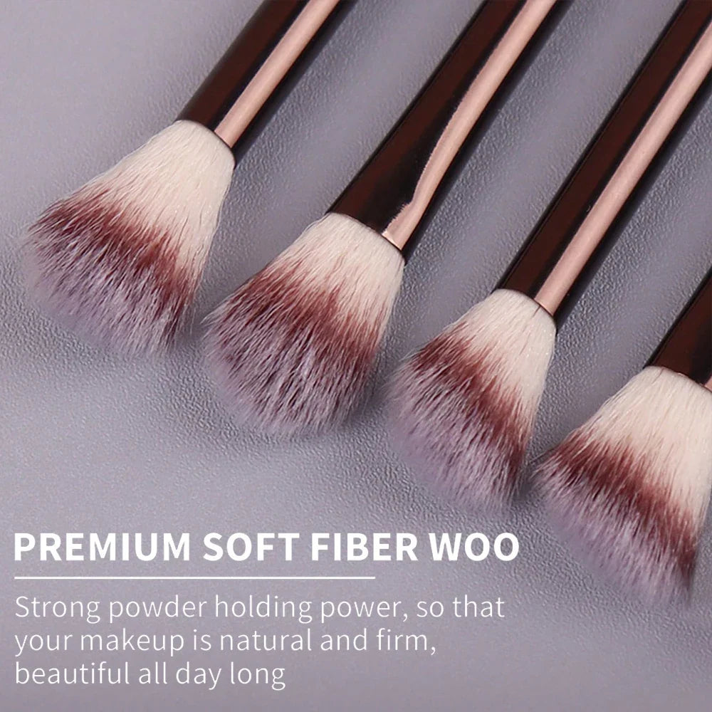 Set of makeup brushes with brown handles and white bristles on a gray textured background.